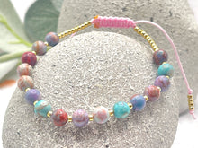 Load image into Gallery viewer, lilac and blue sea sediment stones on a pink cord with tiny gold coloured glass beads to finish it off