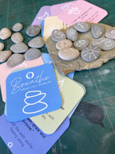 Load image into Gallery viewer, Hand engraved natural beach pebbles for you to use in your 10 breaths practice.  thise pebbles are engraved with grounding affirmation symbols.  They come with a set of 10 affirmation cards for you to use with your stones.
