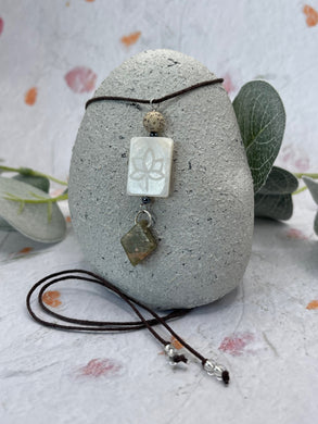 A beautiful mother of pearl focus bead, paired with a diamond shaped Unakit stae and a Lotus Seed Bead on a cotton cord for wearing around your neck